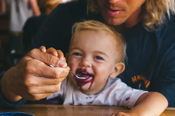 a parent feeding a baby with a spoon